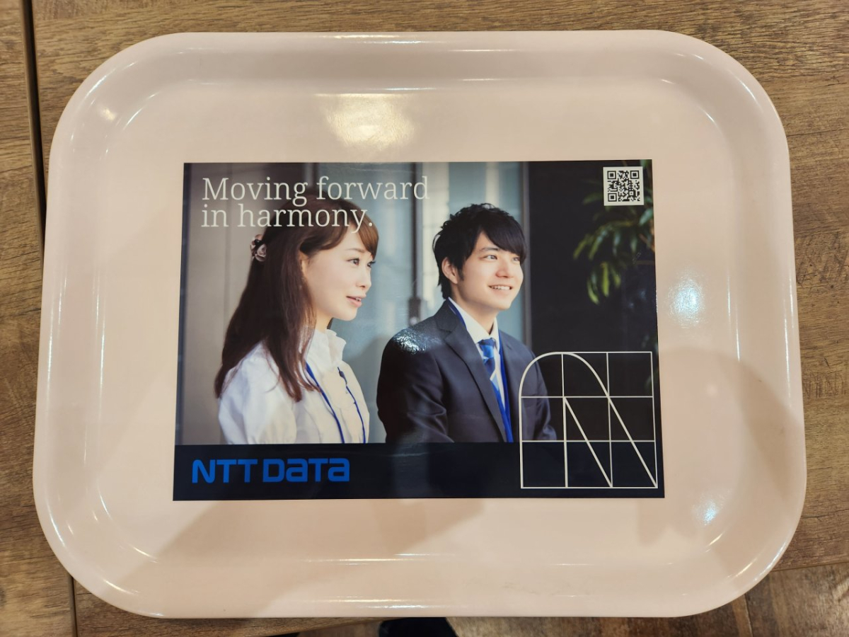 慶應義塾大学三田キャンパスの学食内でトレイ広告