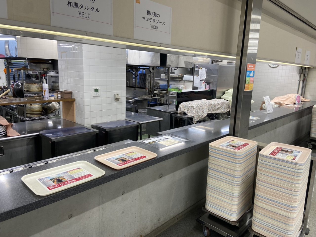 明治大学生田キャンパスの食堂で学食トレイ広告を掲載